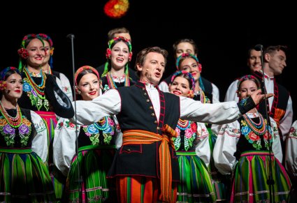 Solista wykonujący utwór Furman, a w tle Artyści z chóru w kostiumach łowickich