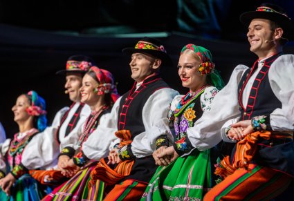 Uśmiechnięci Artyści w kostiumach łowickich na scenie