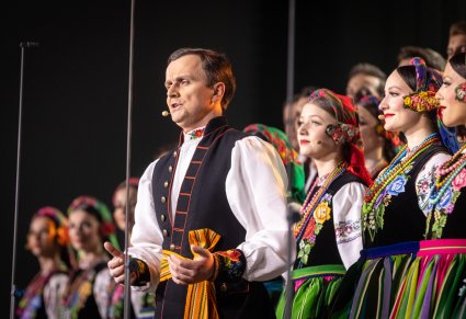 Solista Mazowsza w kostiumie łowickim śpiewa