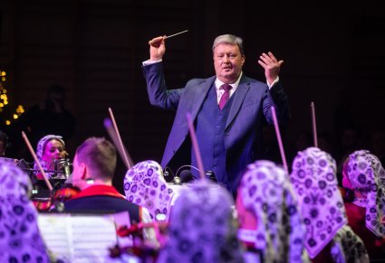 Zbliżenie na maestro Jacka Bonieckiego dyrygującego podczas koncertu
