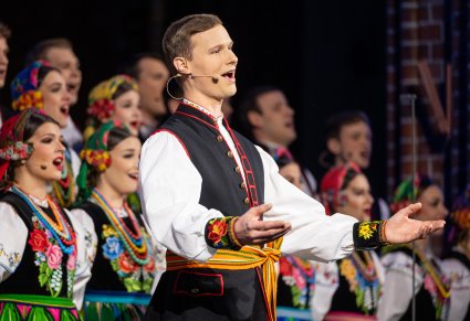 Zbliżenie na solistę w kostiumie łowickim podczas śpiewania kolędy