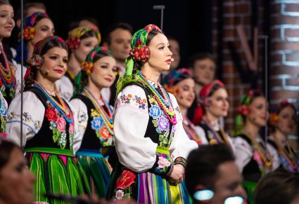 Zbliżenie na solistkę w kostiumie łowickim podczas śpiewania kolędy