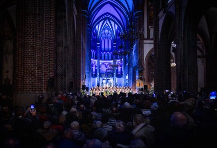 Szeroki widok na wnętrze katedry, chór, orkiestrę i zgromadzoną publiczność