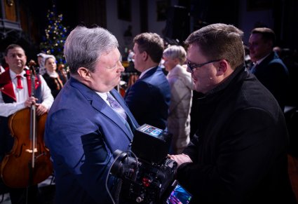 Maestro i ksiądz podają sobie dłonie w podziękowaniu