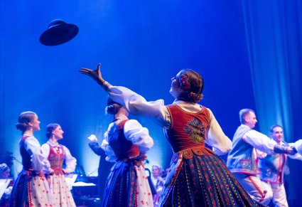 Artystka w tańcu Szczawnica rzuca kapelusz w kierunku tancerza.