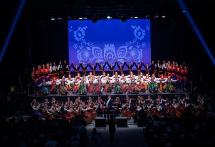 Artyści Zespołu Mazowsze w kostiumach ludowych w scenie finałowej