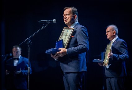 Marszałek Województwa Podkarpackiego przemawia, w tle jeszcze dwie osoby.