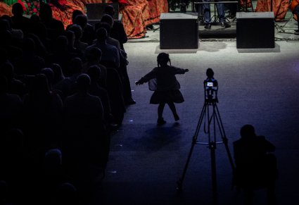 Mała dziewczynka z widowni tańczy przed sceną