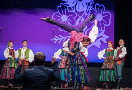 Artyści zespołu Mazowsze w kostiumach opoczyńskich wykonują układ choreograficzny na scenie