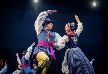 Para artystów zespołu Mazowsze w kostiumach kaszubskich tańczą na scenie