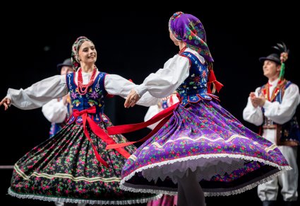 Dwie artystki zespołu Mazowsze w kostiumach limanowskich tańczą na scenie