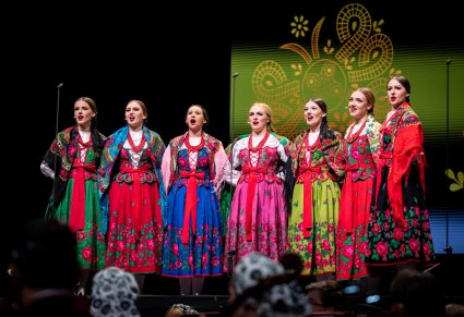 Chórzystki zespołu Mazowsze w kostiumach góralskich śpiewają na scenie