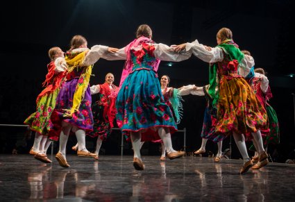 Artystki zespołu Mazowsze w kostiumach góralskich tańczą na scenie w kółku