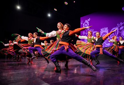 Artyści w kostiumach sannickich tańczą na scenie