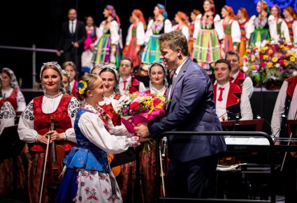 Dyrygent Wojciech Gwiszcz otrzymuje bukiet od artystki Zespołu Pieśni i Tańca "Rzeszowiacy"