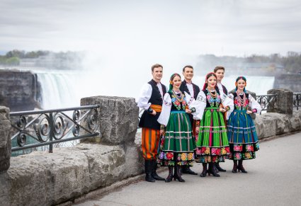 3 pary Artystów w kostiumach łowickich na tle wodospadu Niagara