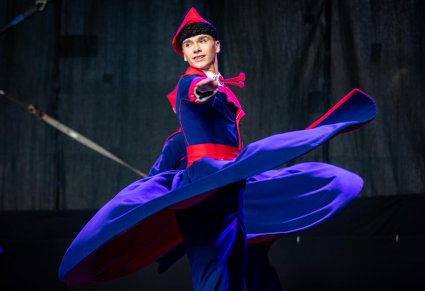 Zbliżenie na tancerza w kostiumie wilanowskim w obrotach na scenie