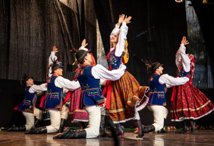 Grupa tancerzy w kostiumach limanowskich w figurach tanecznych