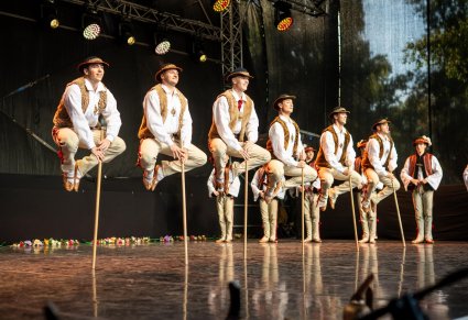 Tancerze w kostiumach jurgowskich podczas akrobacji tanecznych na scenie
