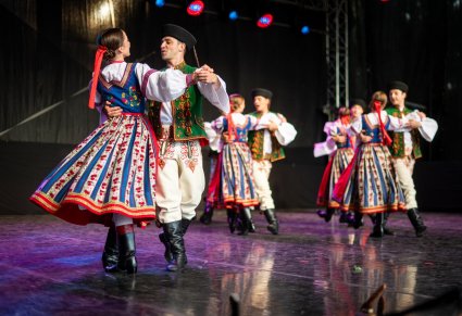 Pary taneczne w kostiumach spiskich w obrotach na scenie