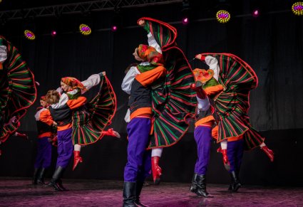 Grupa tancerzy w kostiumach sannickich w podnoszeniu partnerek