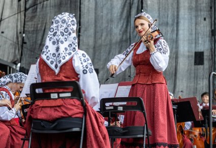 Zbliżenie na artystkę orkiestry grającą na skrzypcach