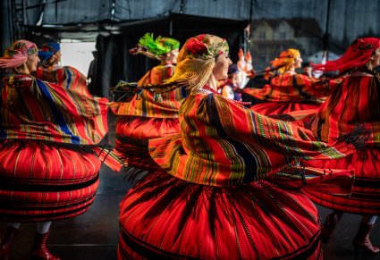 Zbliżenie na tancerki w kostiumach sieradzkich w obrotach