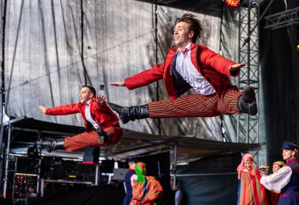 Zbliżenie na tancerzy w kostiumach sieradzkich w akrobacjach tanecznych