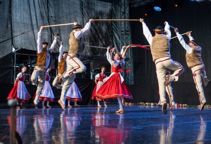 Tancerka i tancerze w kostiumach jurgowskich podczas występu na scenie