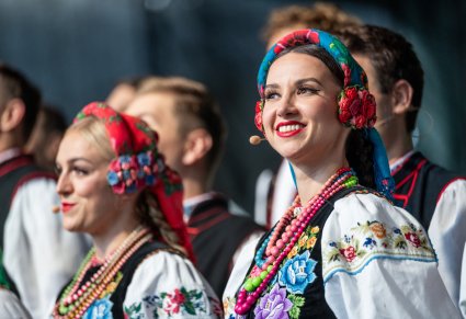 Zbliżenie na artystkę chóru w kostiumie łowickim