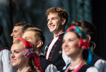 Zbliżenie na artystę chóru w kostiumie łowickim