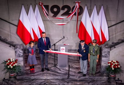 Na scenie Władysław Kosiniak-Kamysz wraz z gośćmi na scenie na ścianie olbrzymi napis 1920 i Polskie flagi