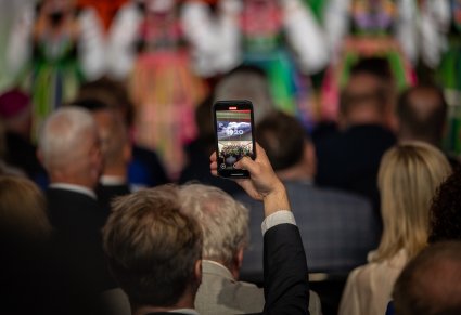 Osoba z publiczności robi zdjęcie telefonem chóru