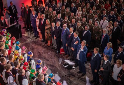 Widok z góry na część chóru w kostiumach łowickich, Dyrektora Jacka Bonieckiego i na część publiczności