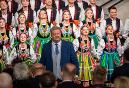 Zbliżenie na chór w kostiumach łowickich i Dyrektora Jacka Bonieckiego