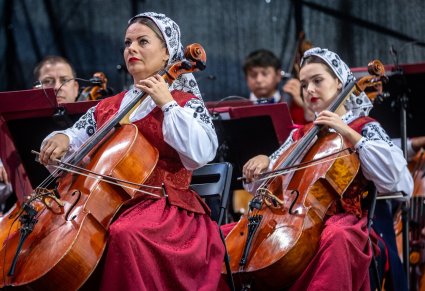 Zbliżenie na artystki orkiestry grające na kontrabasach