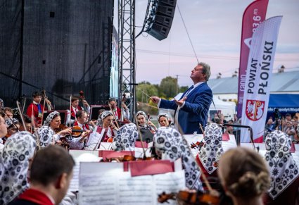 Zbliżenie na dyrektora z orkiestrą podczas koncertu