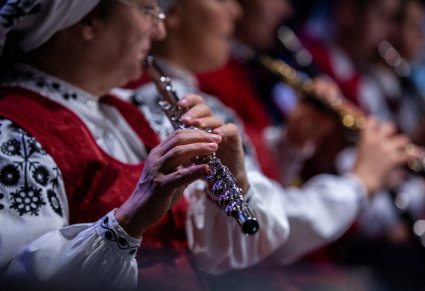 Zbliżenie na artystkę orkiestry grającą na flecie