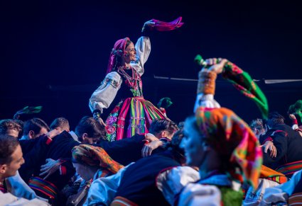 Zbliżenie na artystkę w kostiumie łowickim w układzie finałowym