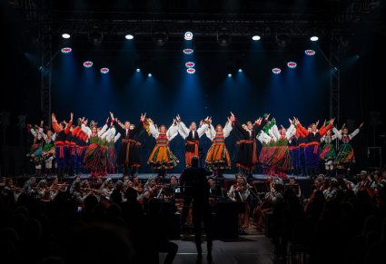 Artyści Zespołu Mazowsze w kostiumach ludowych w scenie finałowej