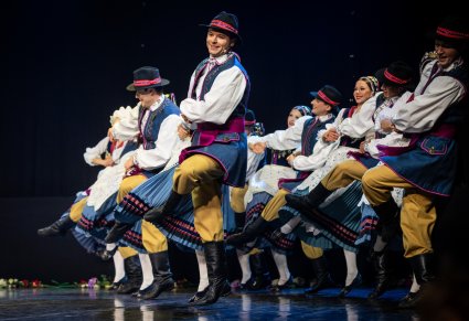 Artyści w kostiumach kaszubskich tańczą na scenie