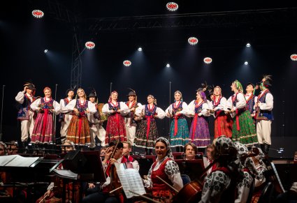Artyści w kostiumach limanowskich śpiewają i tańczą na scenie