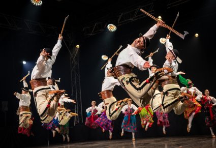 Artyści baletu w kostiumach podhalańskich uchwyceni w podskoku