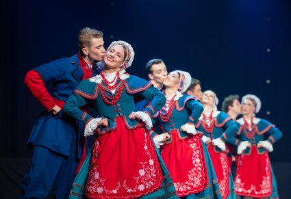 Artyści baletu w kostiumach kujawskich na scenie, panowie całują panie w policzek