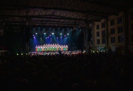 Szerokie ujęcie na wnętrze hali, scenę, zespól oraz zgromadzoną publiczność