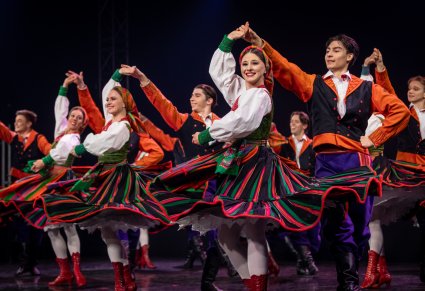 Artyści w kostiumach sannickich tańczą na scenie