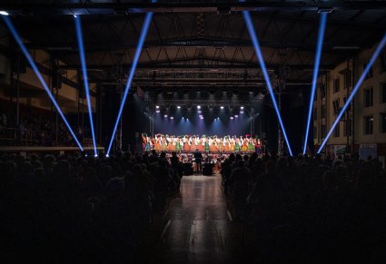 Szerokie ujęcie na wnętrze hali, scenę, zespól oraz zgromadzoną publiczność