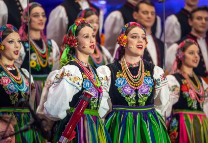 Zbliżenie na chórzystki w kostiumach łowickich śpiewające w duecie kolędę