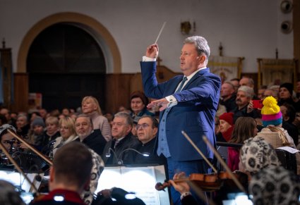 Zbliżenie na dyrygenta podczas koncertu, w tle widoczna widownia