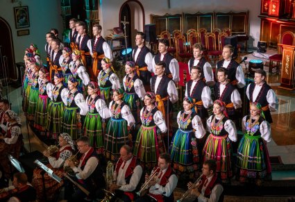 Chór w kostiumach łowickich wykonujący utwór na scenie